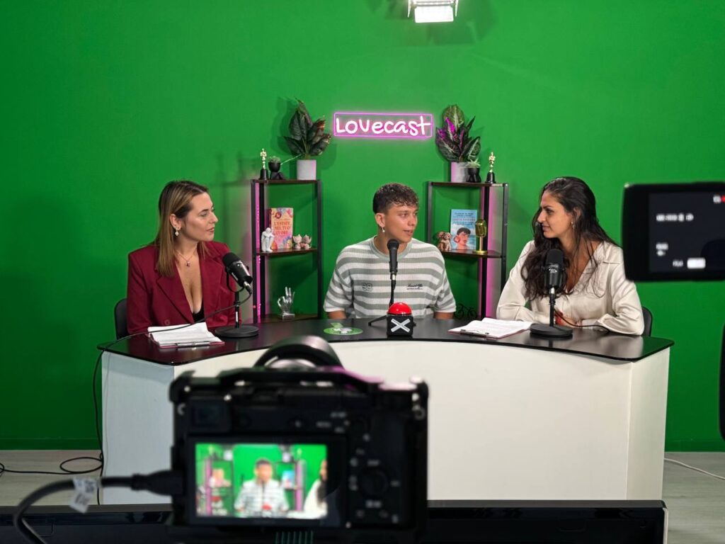 GreenStudio: desk con conduttrice e ospiti davanti alla parete green screen