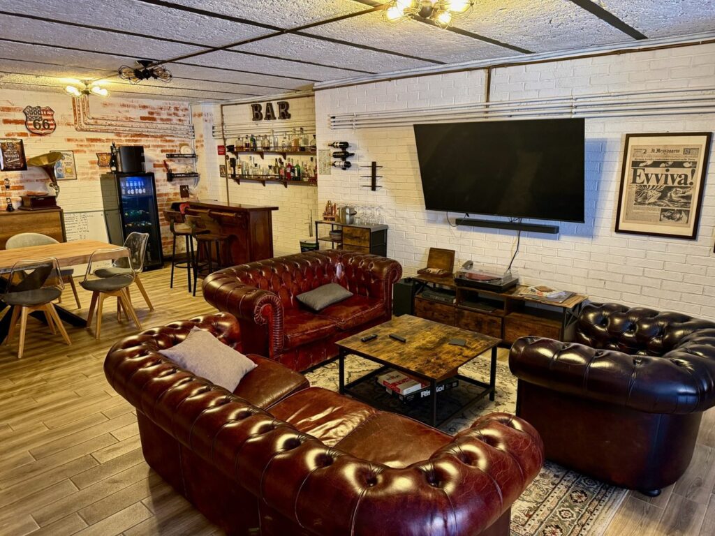 Studio Bunker Roma: salotto industriale con angolo bar e prime pagine storiche